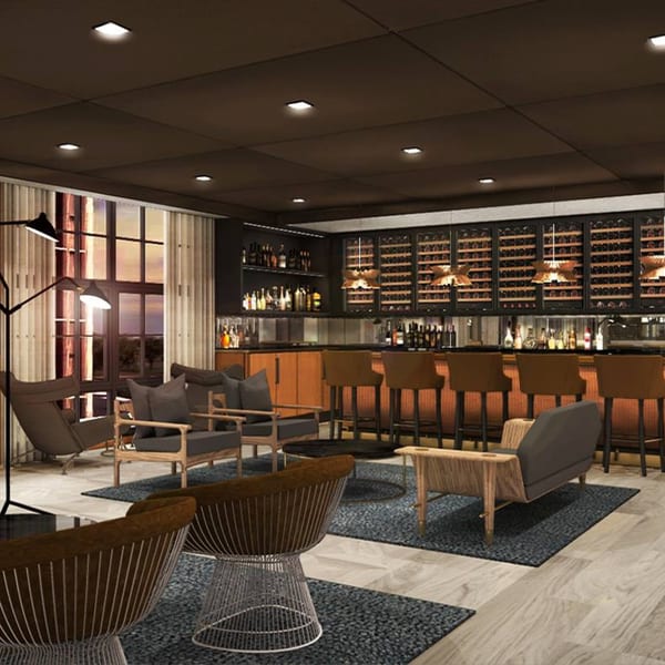 Officina's dimly lit bar area with a long wooden bar, wine racks, and lounge seating.